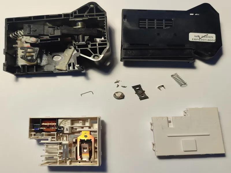 Rozebraný elektronický zámek dvířek pračky LG připravený k opravě